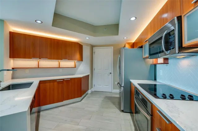 a kitchen with stainless steel appliances a sink a stove and a refrigerator