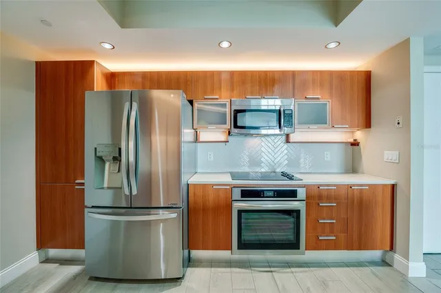 a kitchen with stainless steel appliances granite countertop a refrigerator and a stove