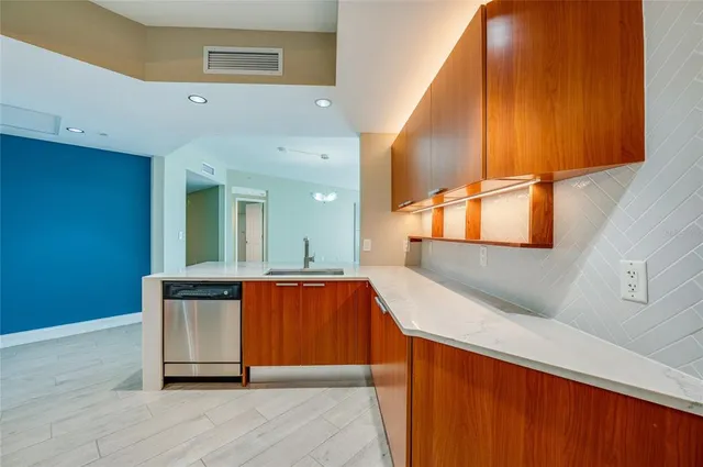 a kitchen with stainless steel appliances granite countertop a sink and a refrigerator