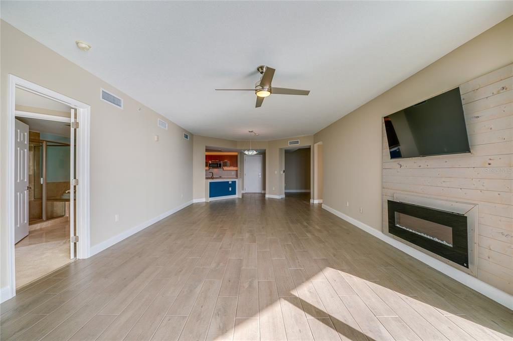 231 Riverside Drive, Unit 1703 Holly Hill, FL 32117 - Photo 10 of 41 a view of a livingroom with a fireplace a flat screen tv and staircase