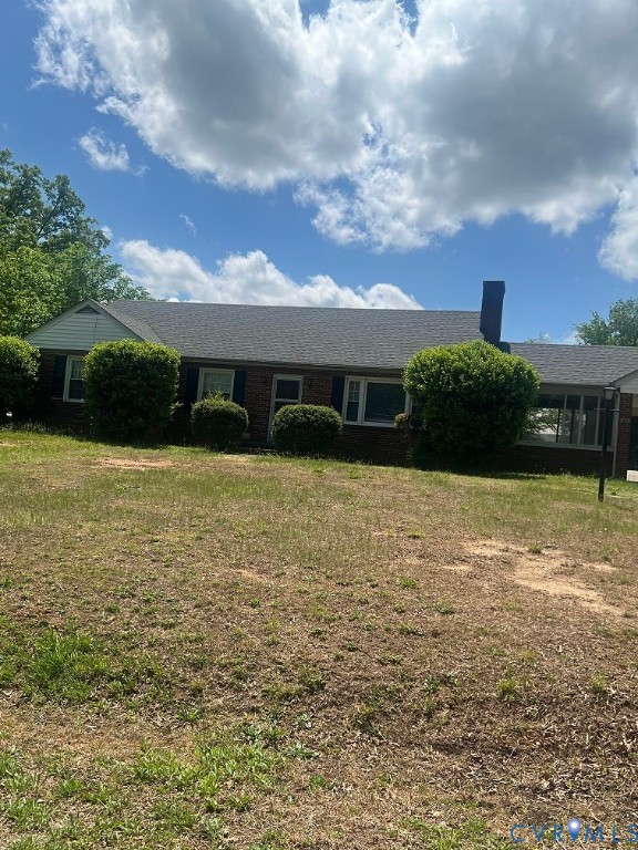 a view of house with yard and outdoor seating