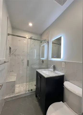 a bathroom with a sink toilet vanity and shower