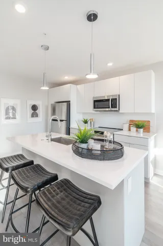 a kitchen with kitchen island a stove a table and chairs in it