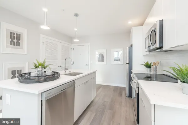 a kitchen with stainless steel appliances kitchen island granite countertop a sink and cabinets