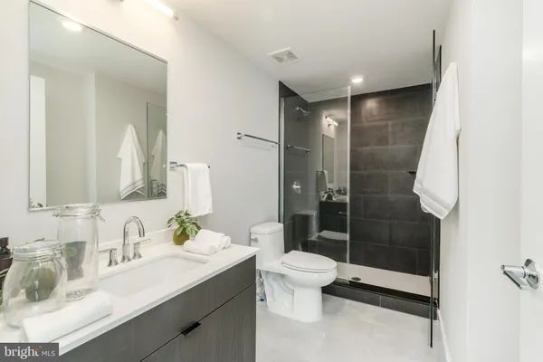 a bathroom with a sink a toilet and shower