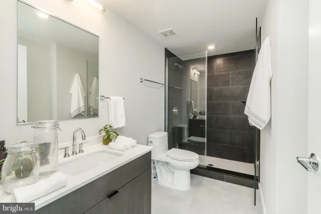 a bathroom with a sink a toilet and shower