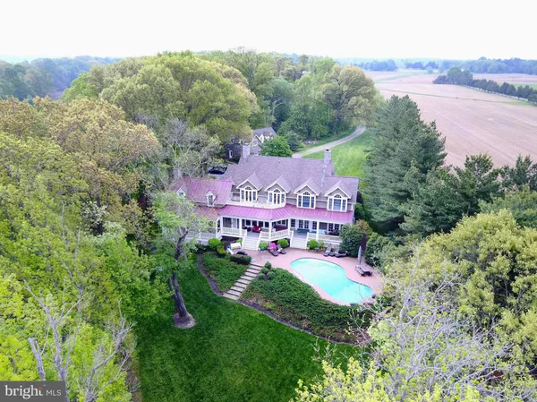 an aerial view of residential house with outdoor space and trees all around