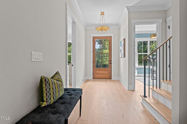 a view of a hallway with wooden floor and a potted plant