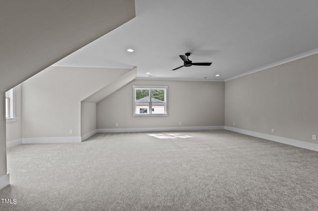 an empty room with a ceiling fan and windows