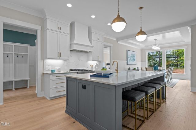 a kitchen with stainless steel appliances granite countertop a sink a stove and a wooden floors