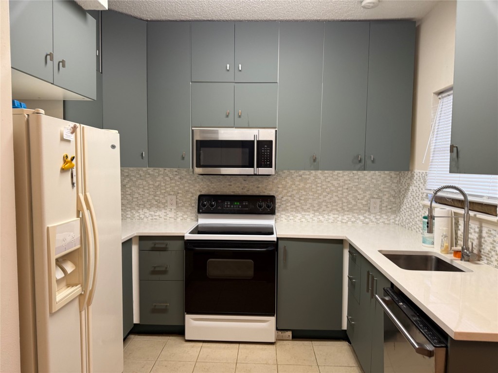7575 Cambridge Street, Unit 2704 Houston, TX 77054 - Photo 13 of 28 a kitchen with a sink a stove and refrigerator