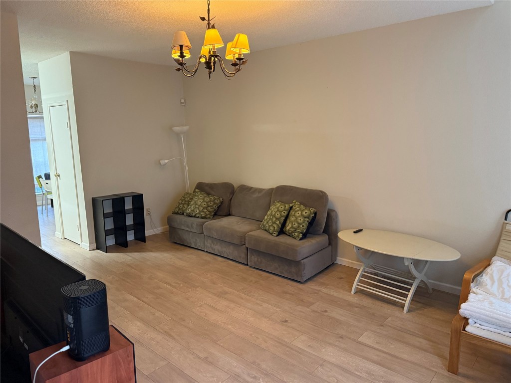 7575 Cambridge Street, Unit 2704 Houston, TX 77054 - Photo 6 of 28 a living room with furniture a couch and a chandelier