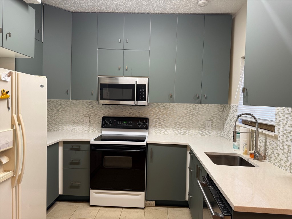 7575 Cambridge Street, Unit 2704 Houston, TX 77054 - Photo 9 of 28 a kitchen with a sink a stove and refrigerator