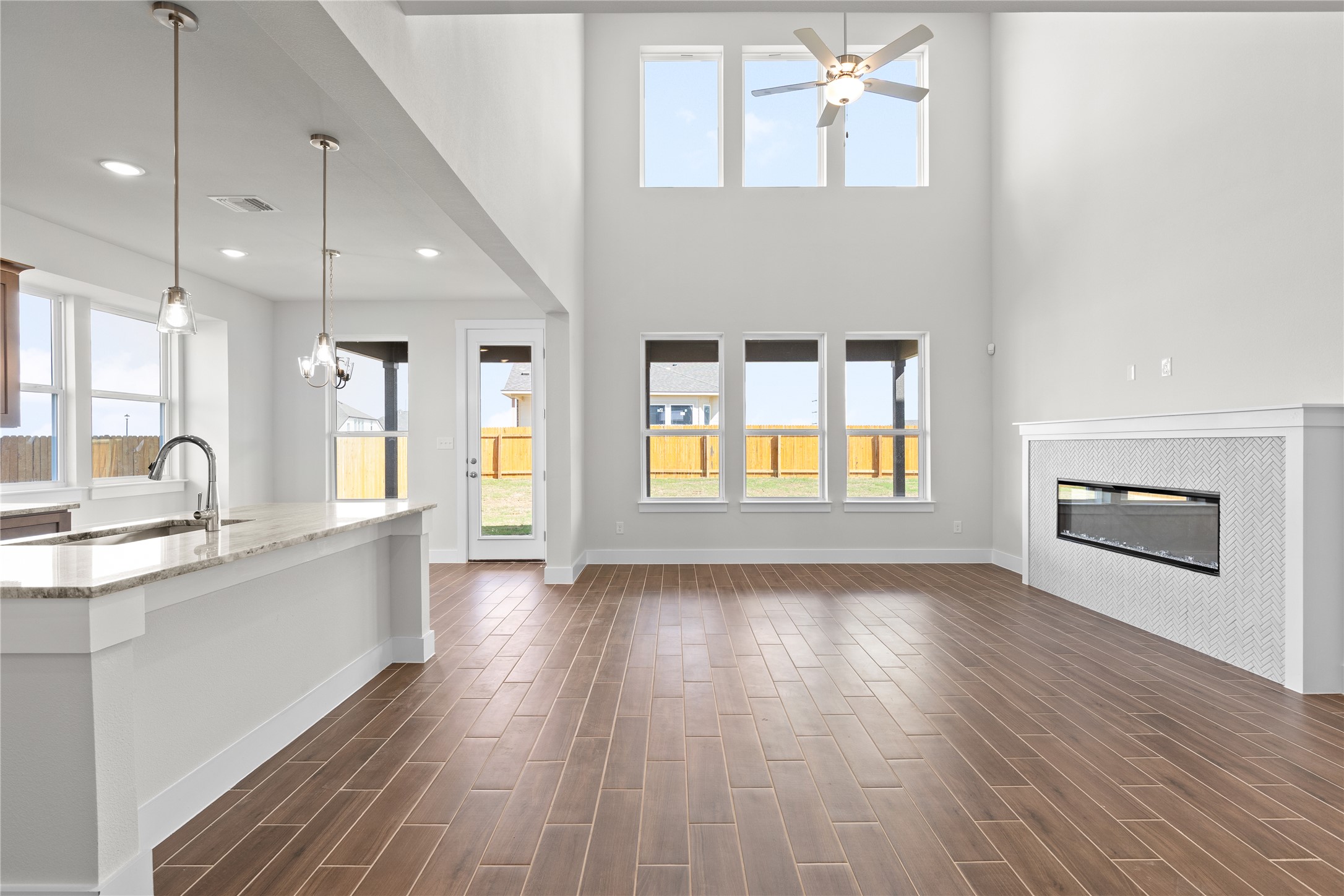 19705 Domino Champ Road Pflugerville, TX 78660 - Photo 11 of 38 Double-height ceilings and a sleek fireplace define this airy, open-concept main level.