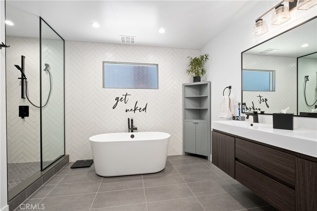 2744 Gannet Drive Costa Mesa, CA 92626 - Photo 24 of 39 a spacious bathroom with a double vanity sink mirror and bathtub