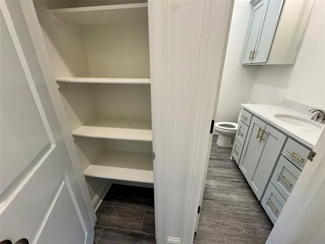 a bathroom with a granite countertop sink a toilet and a mirror