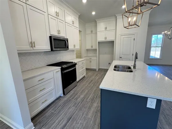 a large living room with stainless steel appliances granite countertop a couch and a fireplace