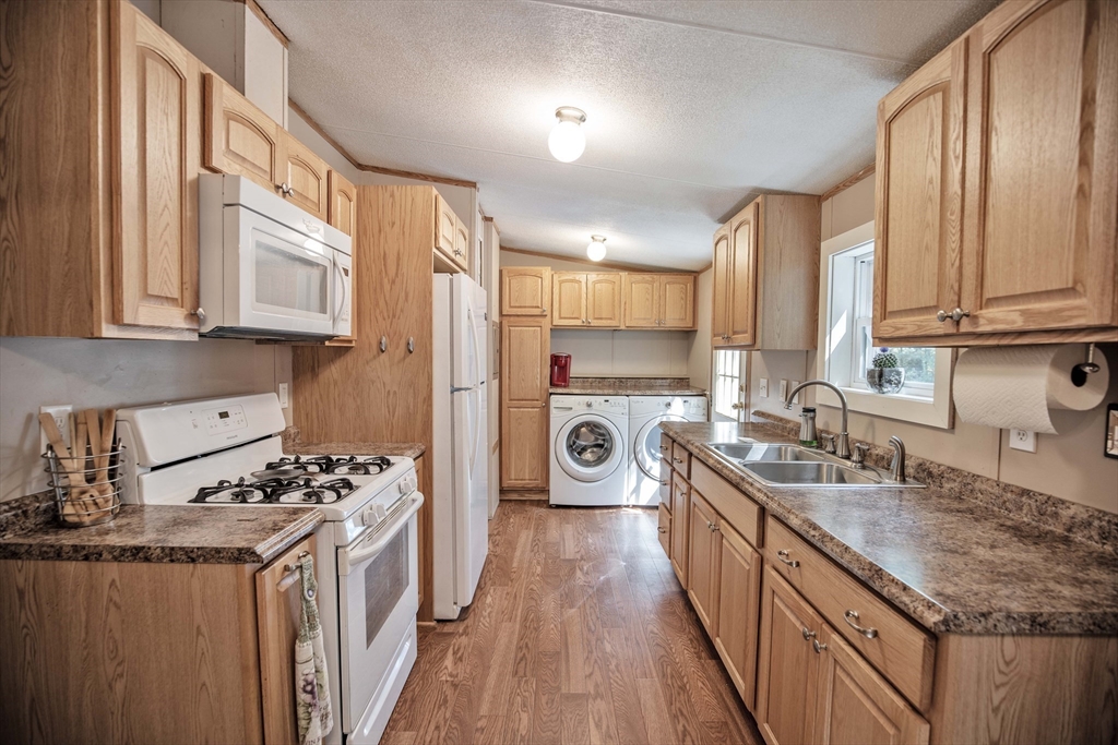 157 Scotland Road Newbury, MA 01951 - Photo 9 of 34 a kitchen with stainless steel appliances granite countertop a stove a sink dishwasher and a refrigerator with wooden cabinets
