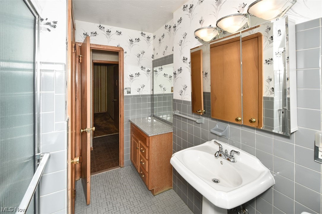 4026 Stonehaven Road Cleveland, OH 44121 - Photo 21 of 30 Bathroom featuring tile flooring, tile walls, sink, and backsplash