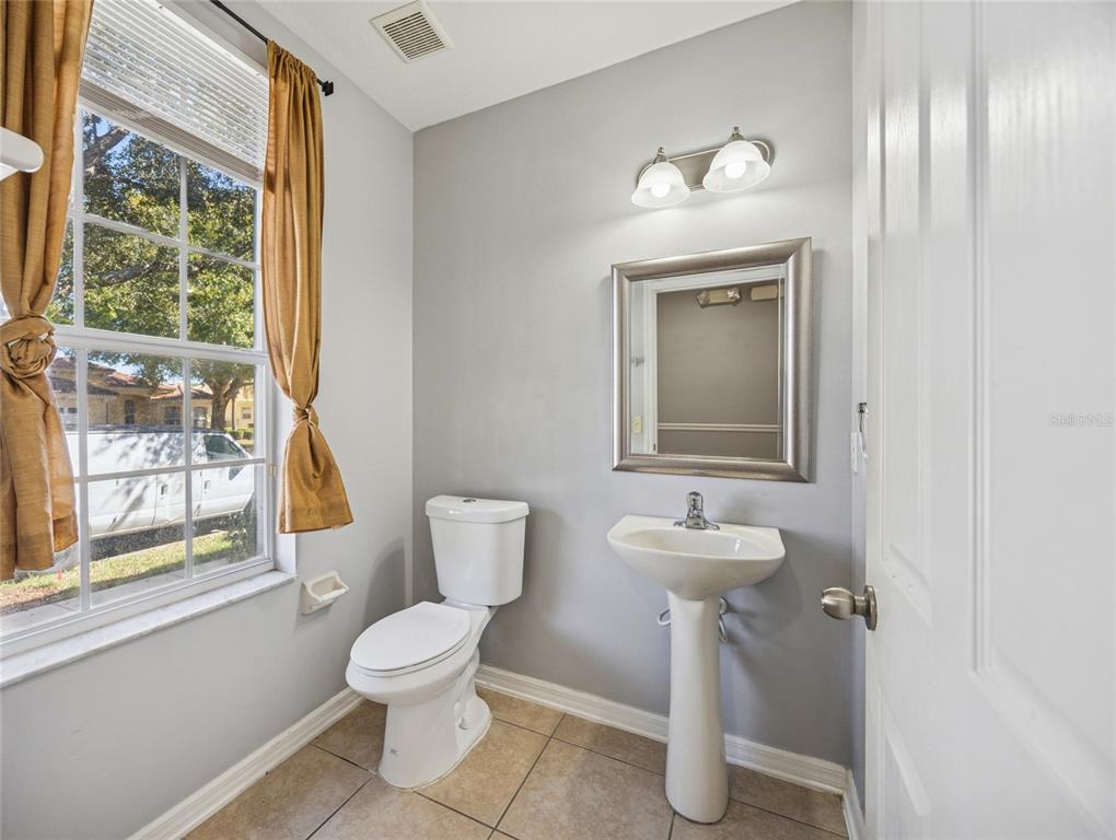 3140 Riachuelo Lane Kissimmee, FL 34744 - Photo 11 of 24 a bathroom with a toilet sink and mirror