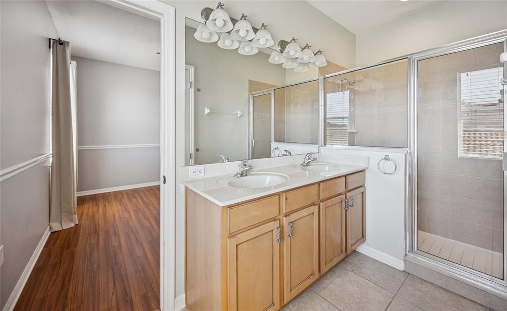 3140 Riachuelo Lane Kissimmee, FL 34744 - Photo 16 of 24 a bathroom with a sink mirror and a shower