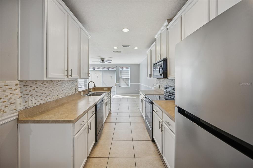 3140 Riachuelo Lane Kissimmee, FL 34744 - Photo 4 of 24 a kitchen with a sink stove and cabinets