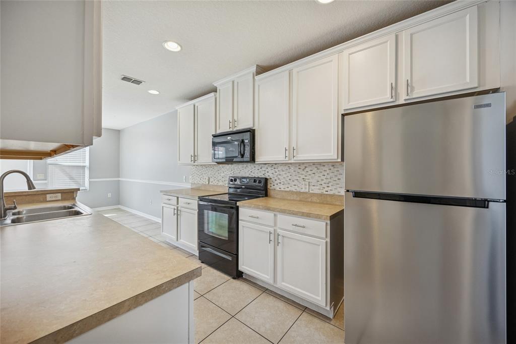 3140 Riachuelo Lane Kissimmee, FL 34744 - Photo 5 of 24 a white refrigerator freezer and a stove in a kitchen