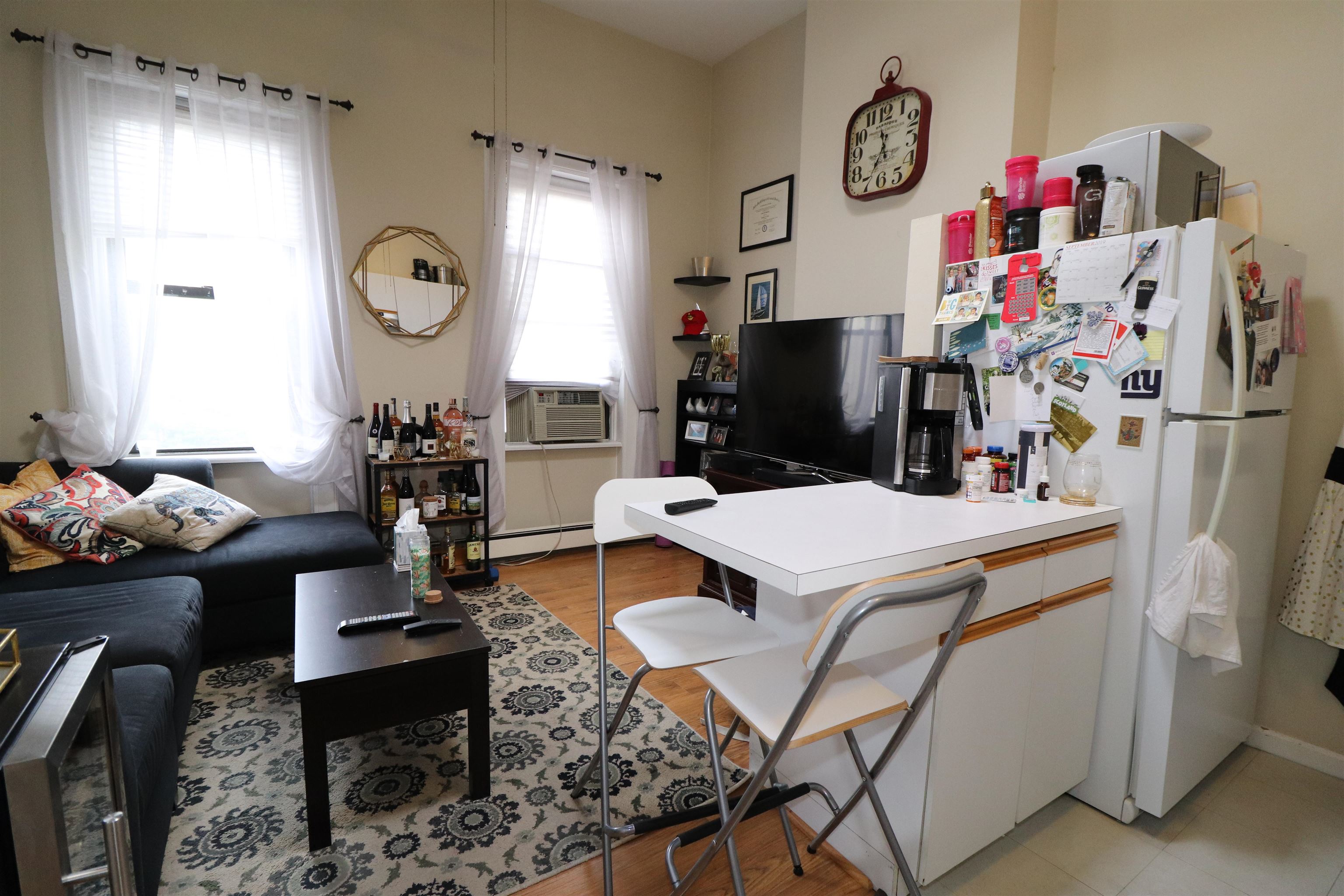 308 8th Street, Unit 2 Hoboken, NJ 07030 - Photo 3 of 8 a living room with furniture a clock on wall and a flat screen tv