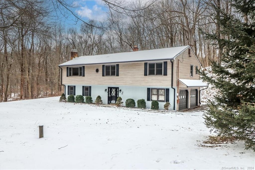 a front view of a house with a yard covered in snow