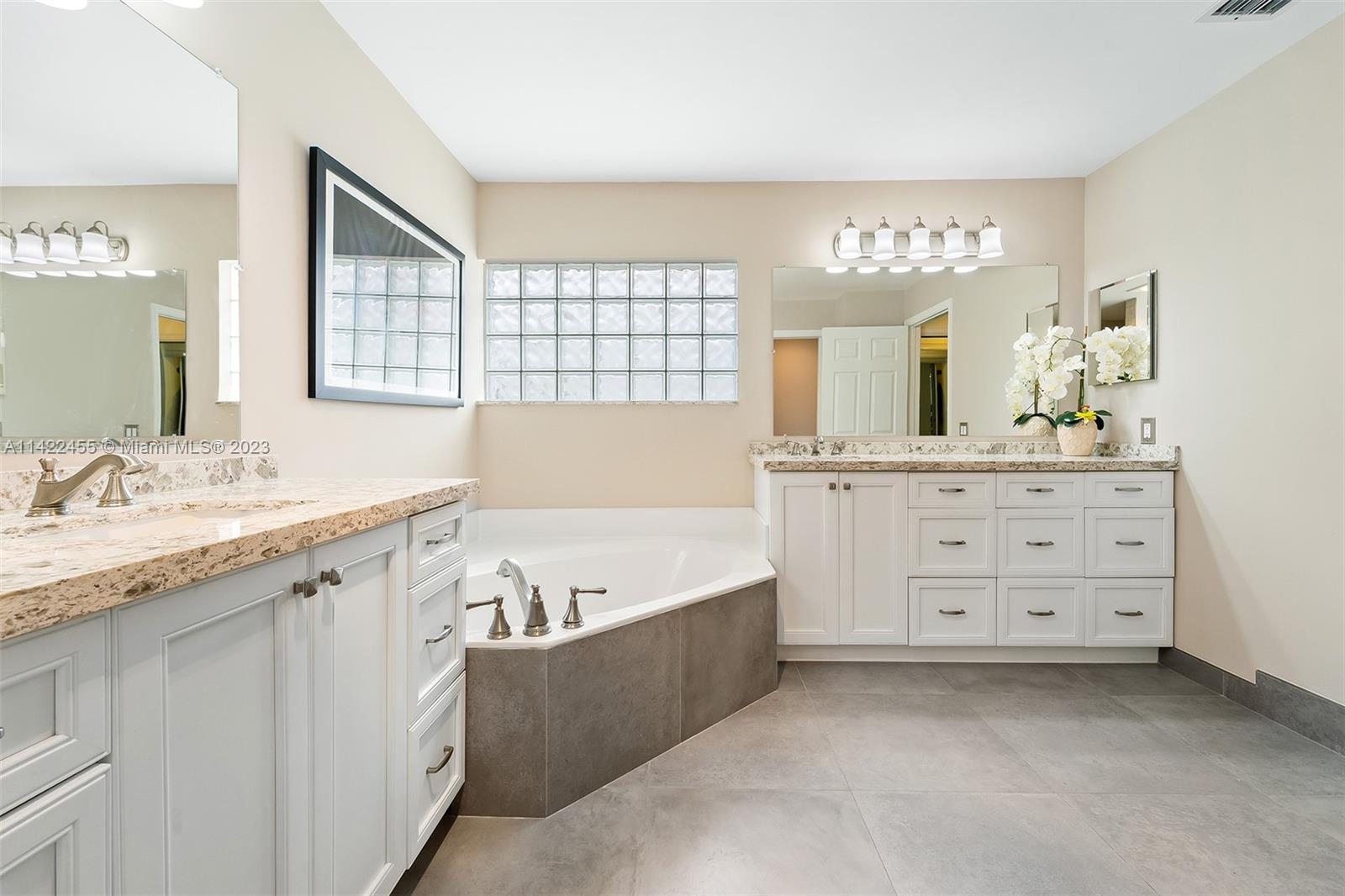 22699 Royal Crown Terrace East Boca Raton, FL 33433 - Photo 11 of 36 a spacious bathroom with a granite countertop sink mirror and a bathtub