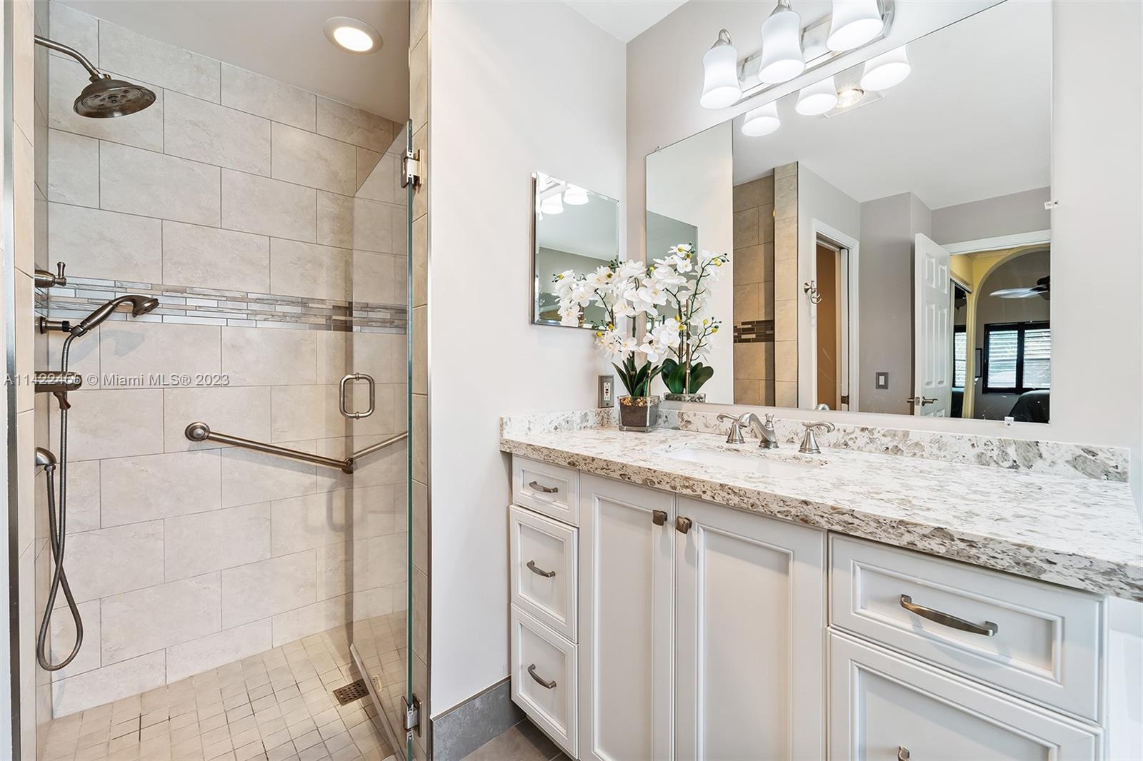 22699 Royal Crown Terrace East Boca Raton, FL 33433 - Photo 12 of 36 a bathroom with a granite countertop shower sink and mirror