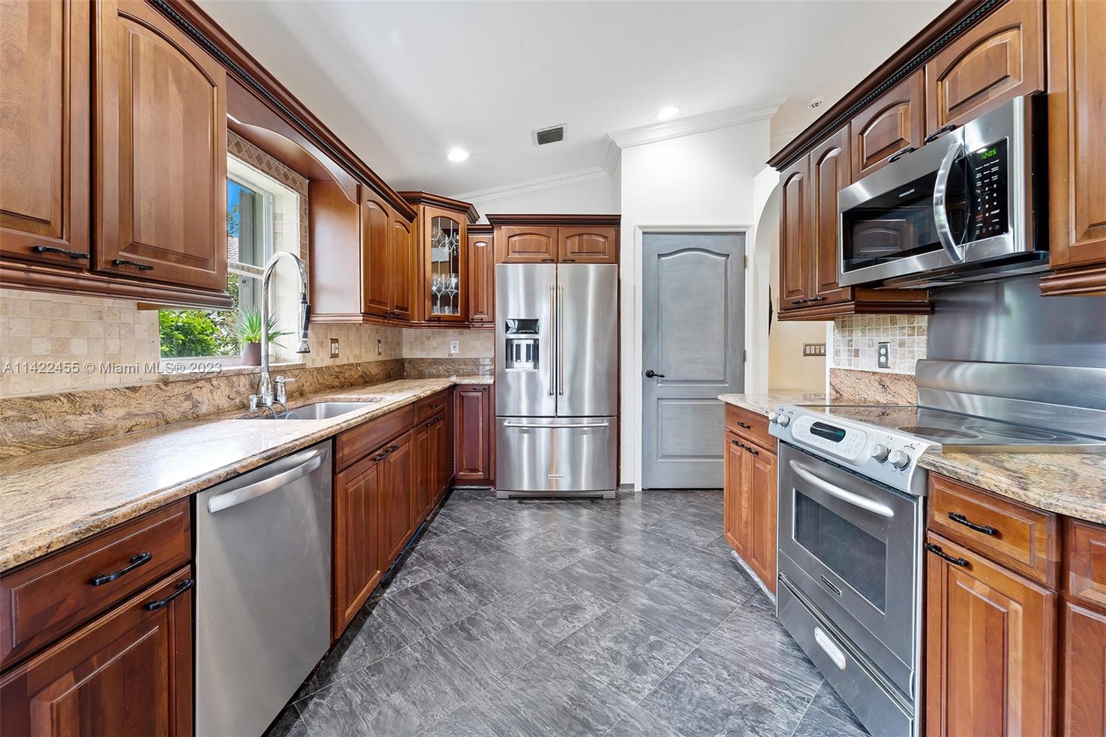 22699 Royal Crown Terrace East Boca Raton, FL 33433 - Photo 19 of 36 a large kitchen with stainless steel appliances granite countertop a stove a sink dishwasher a refrigerator and a microwave