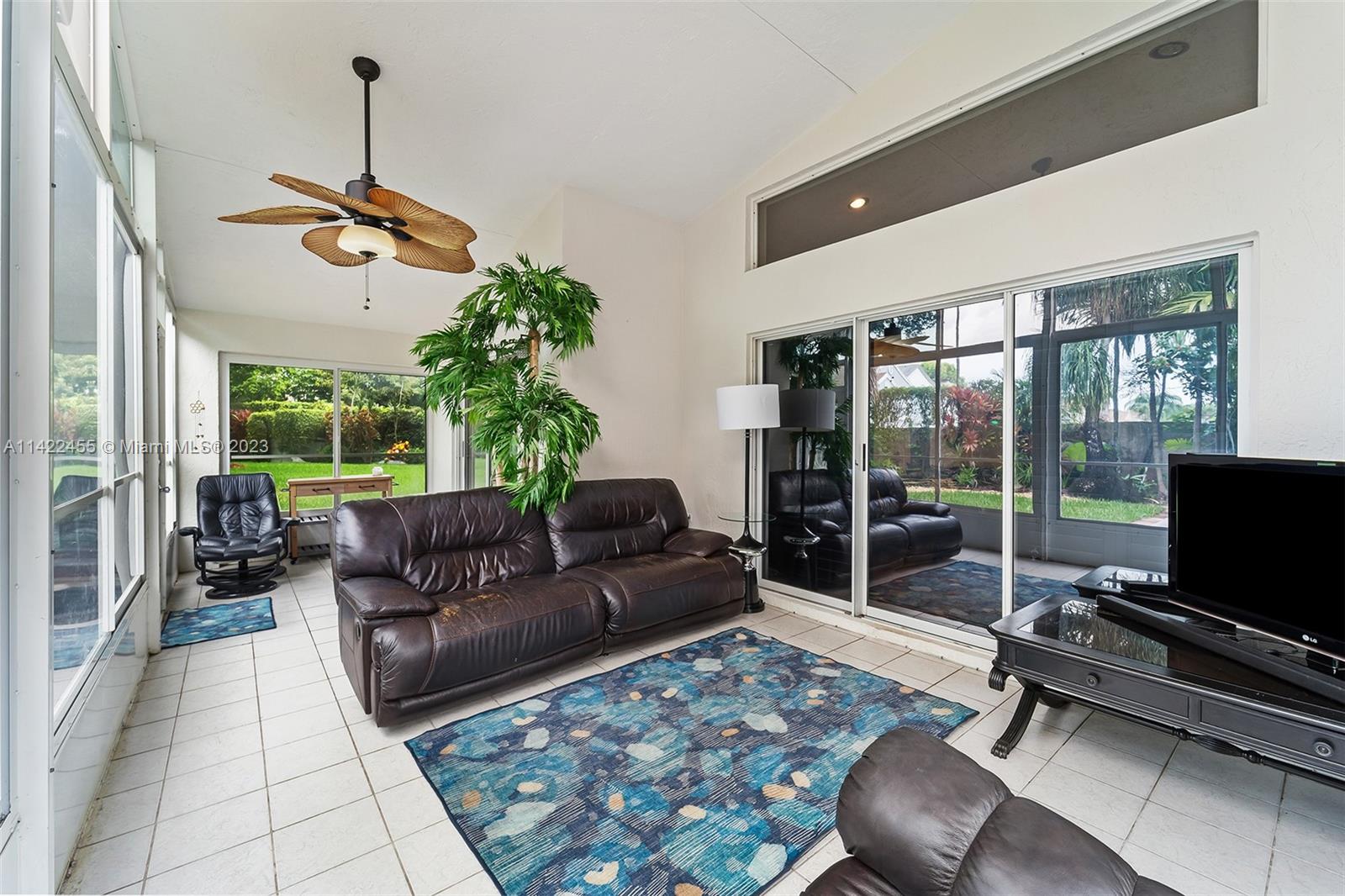 22699 Royal Crown Terrace East Boca Raton, FL 33433 - Photo 20 of 36 a living room with furniture a flat screen tv and a floor to ceiling window