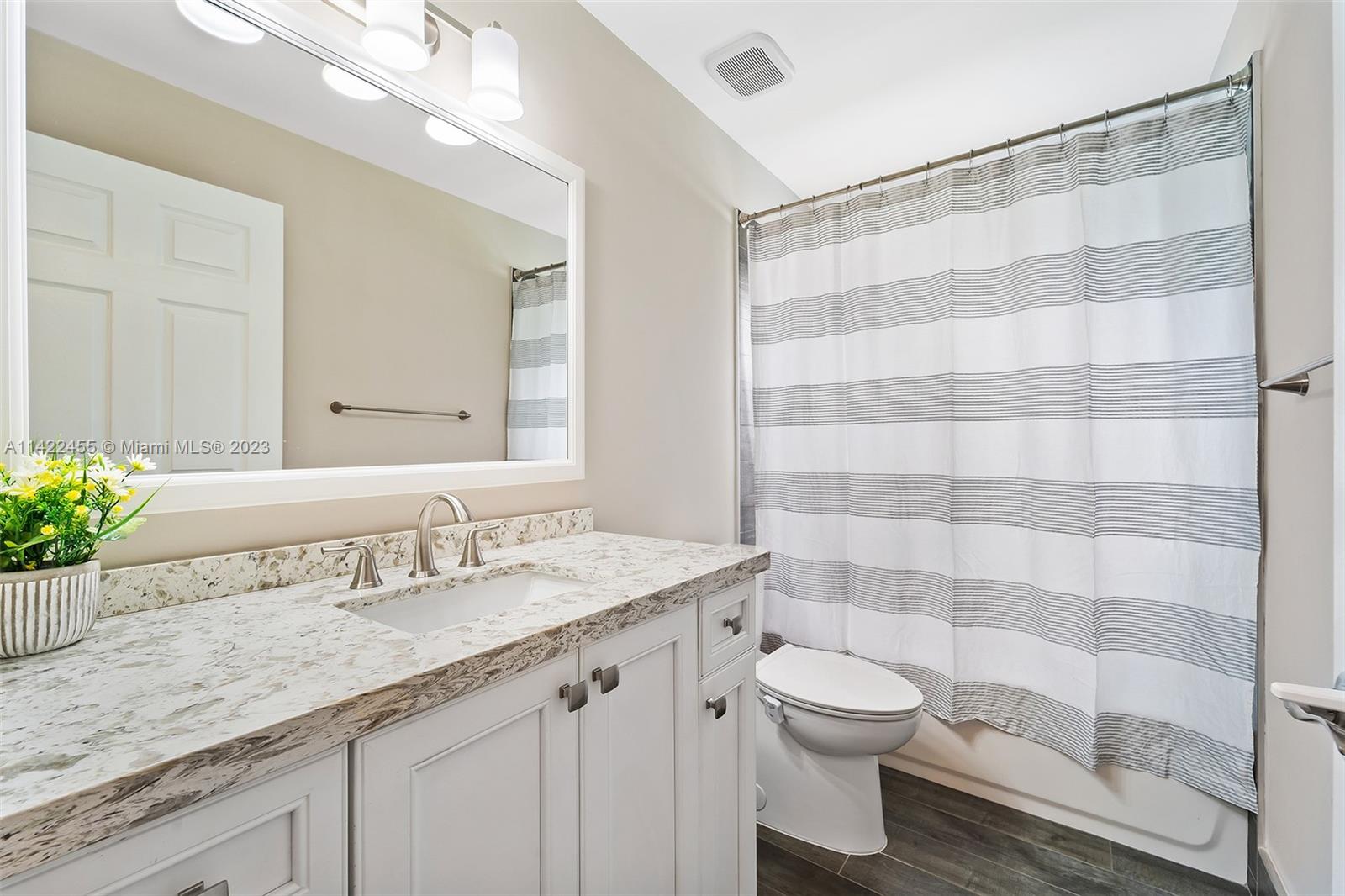 22699 Royal Crown Terrace East Boca Raton, FL 33433 - Photo 9 of 36 a bathroom with a granite countertop sink a toilet and a mirror