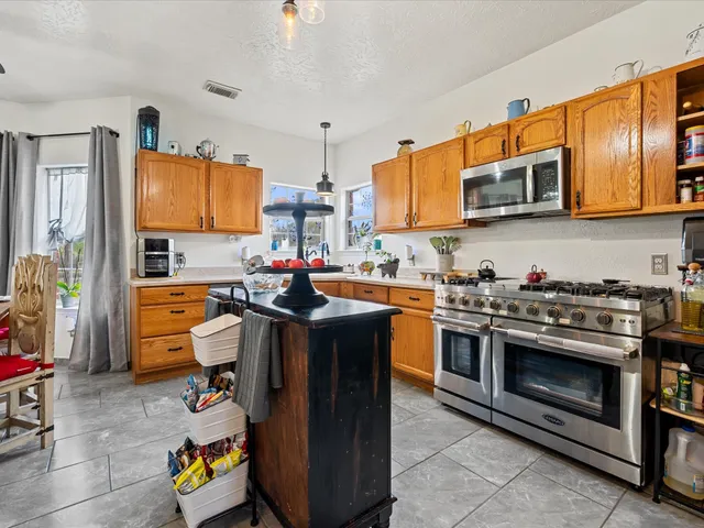 a kitchen with stainless steel appliances a stove a sink dishwasher and cabinets with wooden floor