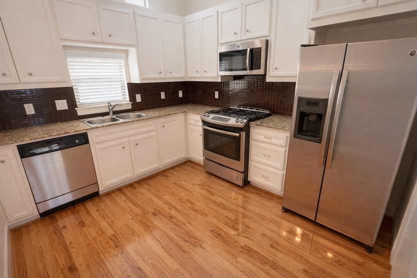 2710 Hullsmith Drive, Unit 803 Houston, TX 77063 - Photo 6 of 21 a kitchen with granite countertop a refrigerator sink and microwave