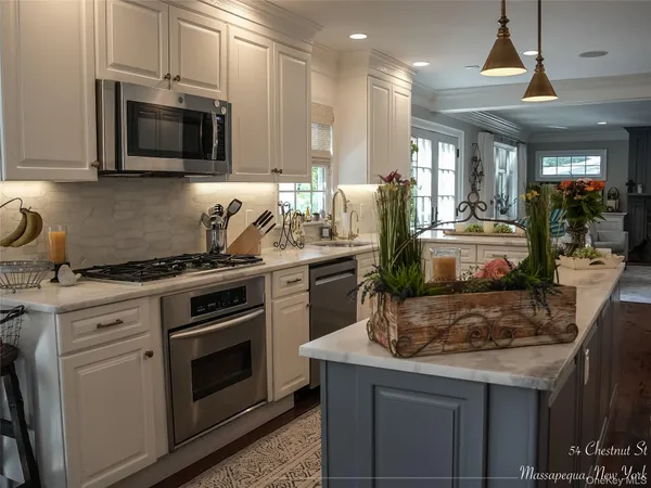 a kitchen with stainless steel appliances kitchen island granite countertop a stove and a sink