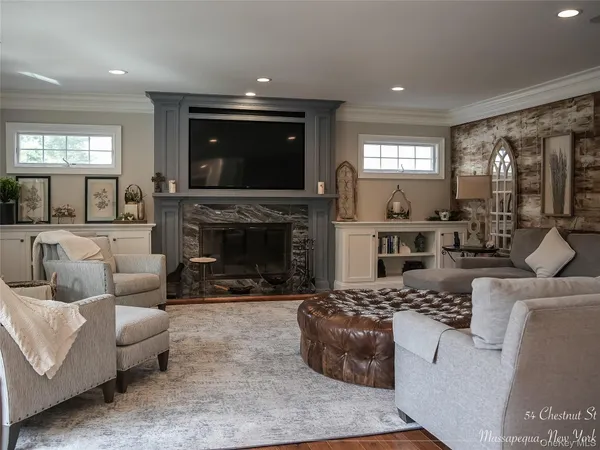 a living room with furniture a flat screen tv and a fireplace