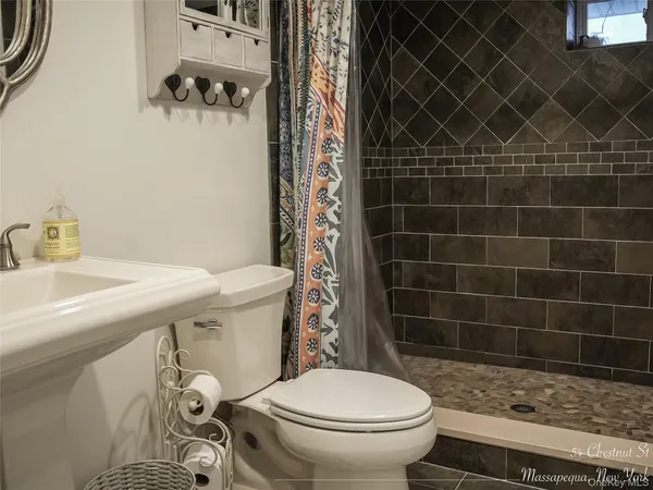 a bathroom with a sink a toilet and a mirror