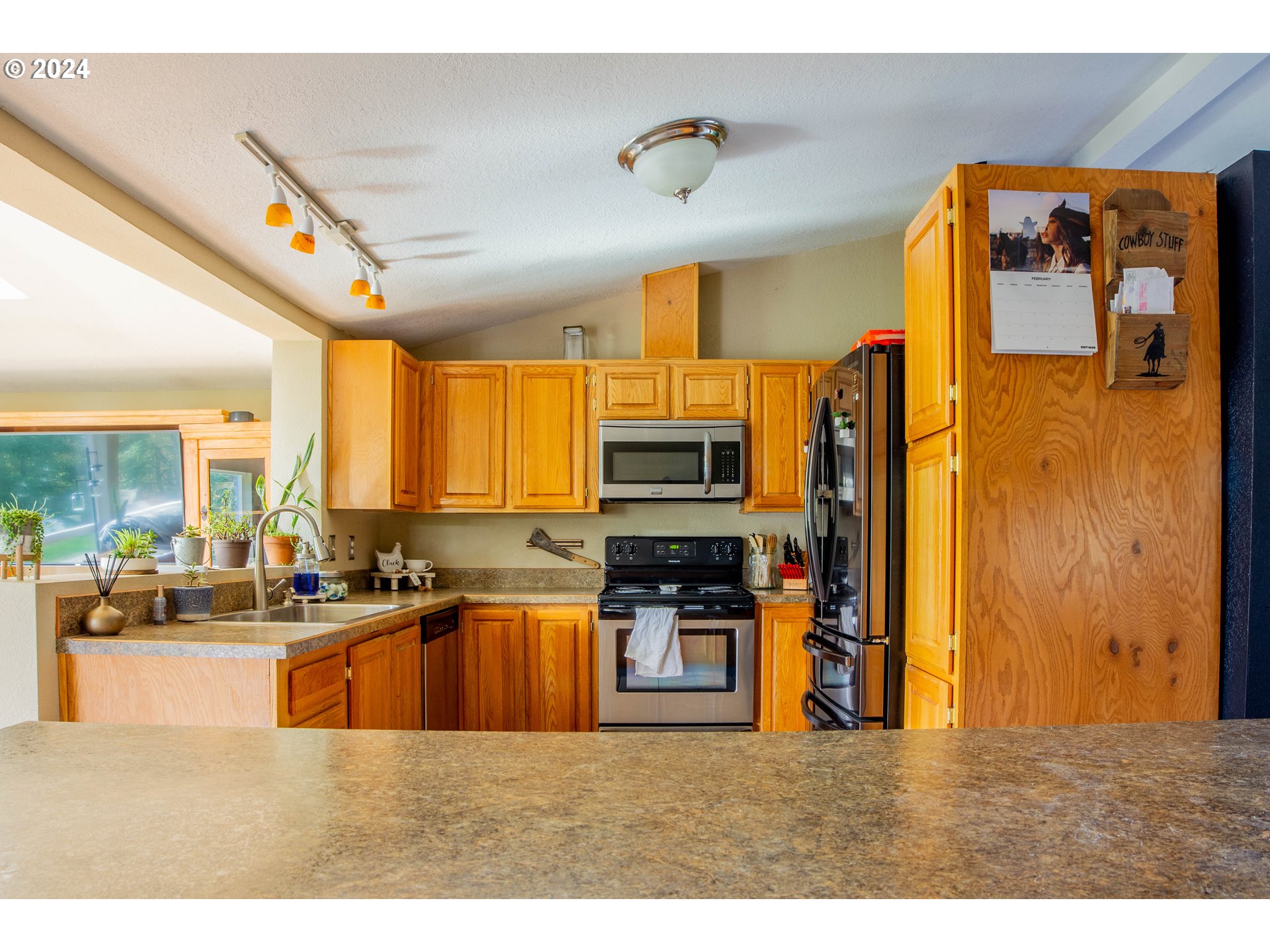 34221 Bond Road Lebanon, OR 97355 - Photo 8 of 45 a kitchen with stainless steel appliances kitchen island granite countertop a sink refrigerator and cabinets