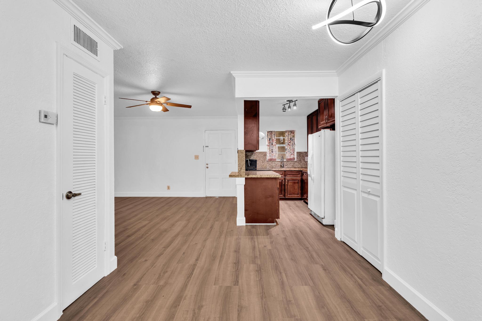 1291 Northwest 13th Street, Unit 445D Boca Raton, FL 33486 - Photo 29 of 50 a room with wooden floors and white walls