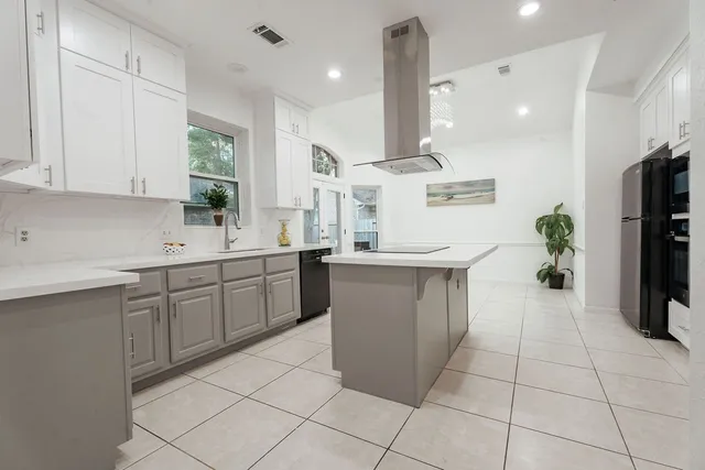 a kitchen with stainless steel appliances kitchen island granite countertop a sink and cabinets