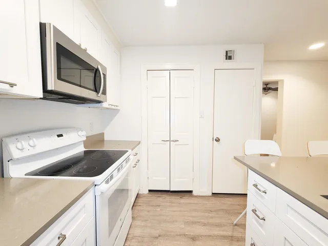 a kitchen with stainless steel appliances granite countertop a sink and a stove