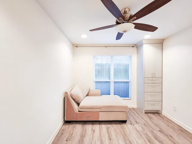 a spacious bedroom with a bed and a ceiling fan