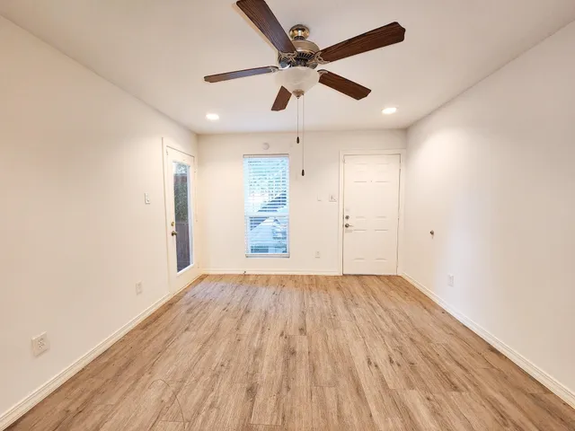 an empty room with wooden floor a ceiling fan and closet