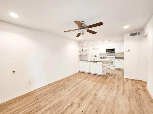 a view of kitchen with wooden floor and electronic appliances