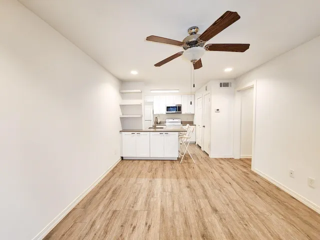 a view of a kitchen with a sink and wooden floor