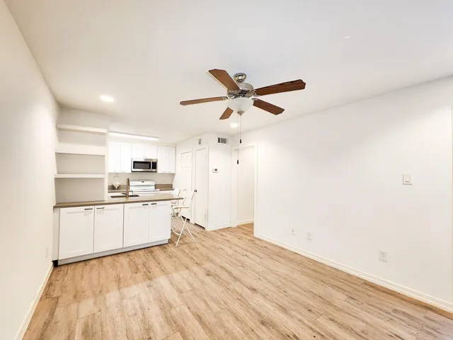 a kitchen with a refrigerator and white cabinets