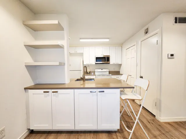 a kitchen with white cabinets and sink
