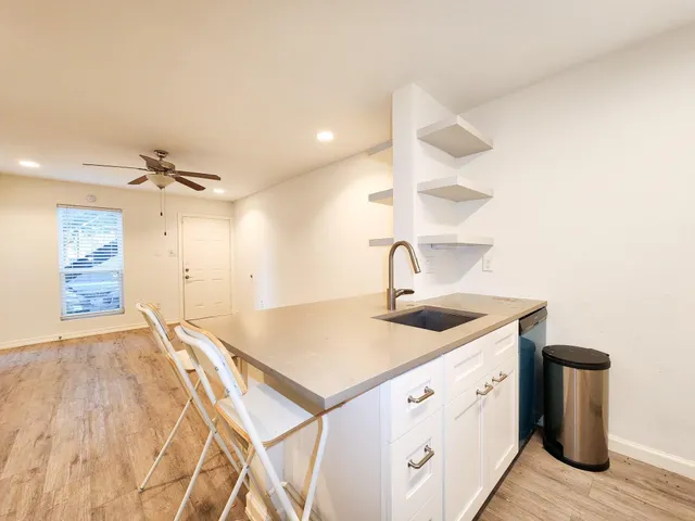 a kitchen with a sink cabinets and wooden floor